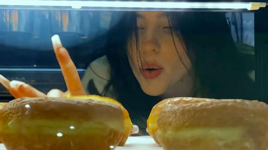 Billie Eilish eyes glazed doughnuts as she sings her newest single Therefore I am.