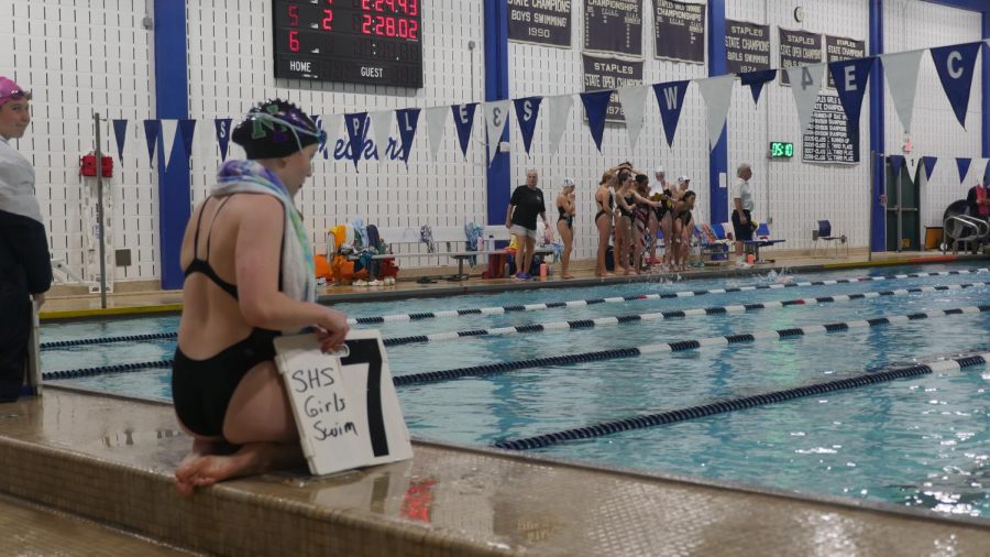 Junior Samantha Taylor notifying the swimmer which lap they are on.